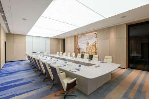 Kew Green Hotel Hongqiao Shanghai في شانغهاي: قاعة اجتماعات كبيرة مع طاولة وكراسي طويلة