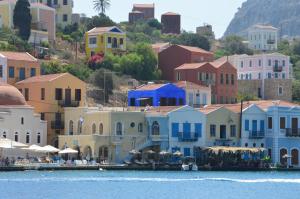 a group of houses on a hill next to the water at Casa Muse Kastellorizo Whole House in Meyisti