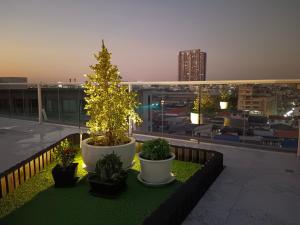 uma varanda com uma árvore de Natal e vasos de plantas em S3 Siam Bangkok Hotel em Bangkok