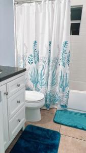a bathroom with a toilet and a shower curtain at Pool house near beach in West Melbourne