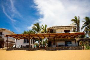 a house on the beach with a wooden pergola at Hotel Playa Zipolite in Zipolite