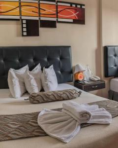 Un dormitorio con una cama con una toalla. en Hotel Alto Mar, en Catia La Mar