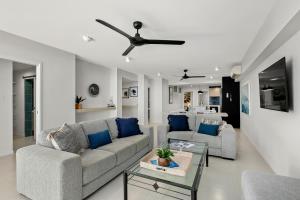 un soggiorno con 2 divani e un tavolo di Belle Escapes Oceanview Suite 21 Alamanda Palm Cove a Palm Cove