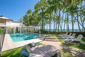 una casa con piscina e palme di Belle Escapes Oceanview Suite 21 Alamanda Palm Cove a Palm Cove