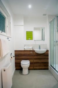 a bathroom with a toilet, sink and tub at Helix Hotel in Grangemouth