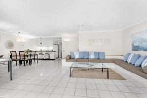 sala de estar con sofá y mesa en Belle Escapes Poolview Suite 74 Alamanda Resort Palm Cove, en Palm Cove