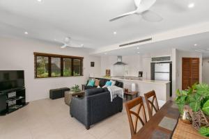 a living room with a couch and a kitchen at Belle Escapes Ground Floor Beachfront Apartment in Yorkeys Knob