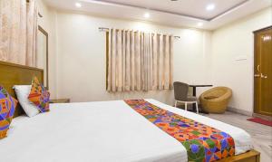 a bedroom with a bed and a desk and a chair at FabHotel The Eden Ruby in Kolkata