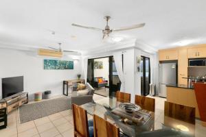 a living room with a dining table and a kitchen at 604 Chic City Apartment with Water Views in Cairns