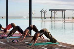 a group of people doing yoga by the water at 604 Chic City Apartment with Water Views in Cairns