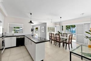 cocina y comedor con mesa y sillas en Belle Escapes Oceanview Suite 48 with Private Pool Alamanda Resort Palm Cove, en Palm Cove