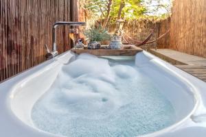 a bath tub filled with water next to a fence at הבית החום יחידת אירוח לזוגות ומטיילים בערבה in Sappir +22 photos