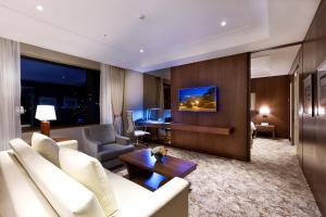 sala de estar con sofá blanco y TV en Hotel Hyundai by Lahan Ulsan, en Ulsan