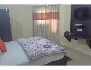 a bedroom with a bed and a tv in a room at Hotel Kailash, Amritsar in Amritsar