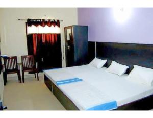 sypialnia z dużym łóżkiem i 2 krzesłami w obiekcie Hotel Kailash, Amritsar w mieście Amritsar