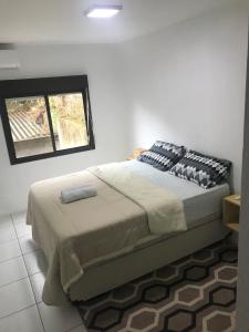 a bedroom with a large bed with a window at Apartamento encantador em bairro Nobre. in Santa Cruz do Sul