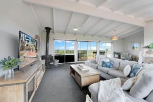 a living room with a couch and a tv at Beachside House in Tootgarook