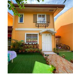 a house with a green lawn in front of it at Hillview Apt w/ Pool Access - Free Wifi in Tagbilaran City