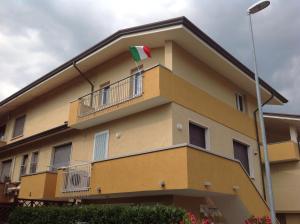 トッレ・デル・ラーゴ・プッチーニにあるLa casa dei coloriの旗のある建物