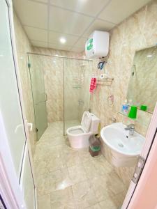 a bathroom with a shower and a toilet and a sink at Sky Halong Apartment in Ha Long