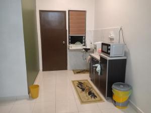a small kitchen with a microwave on a counter at Homestay Bonda, Taman Mayung, Teluk Kemang - Private Children Pool - Malay Only in Kampung Teluk Kemang +3 photos