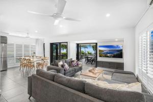 a living room with a couch and a table at Belle Escapes Beachfront Luxury Home 53 Arlington Clifton Beach in Palm Cove