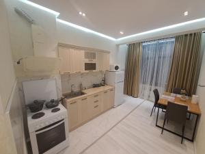 a kitchen with a table and a stove top oven at Apartment in City Centre in Dushanbe