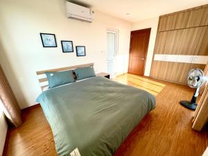a bedroom with a bed and a fan at Sky Halong Apartment in Ha Long