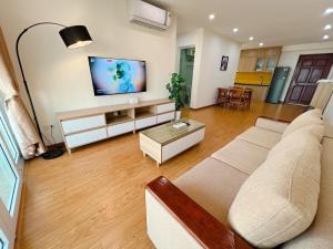 sala de estar con sofá y TV de pantalla plana en Sky Halong Apartment en Ha Long