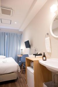 a room with a bed and a sink and a desk at ELE Hotel Ginza East in Tokyo