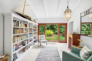 a living room with book shelves filled with books at Belle Escapes Tropical Haven Holiday Home Palm Cove in Palm Cove