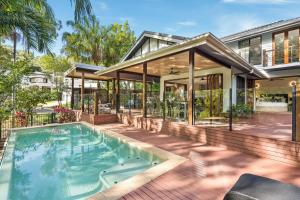 an exterior view of a house with a swimming pool at Belle Escapes Watermark Palm Cove Luxury Home in Palm Cove