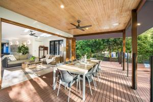 un patio abierto con mesa y sillas en Belle Escapes Watermark Palm Cove Luxury Home, en Palm Cove