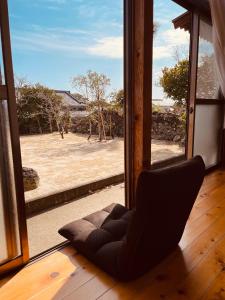 einem schwarzen Stuhl vor einem Fenster in der Unterkunft Goto I-House in Goto