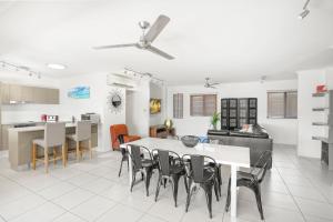 cocina y sala de estar con mesa y sillas en Belle Escapes Waterview Penthouse 404 The Edge en Cairns