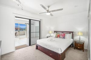 a bedroom with a bed and a ceiling fan at Belle Escapes 404 The Edge with Views in Cairns +17 photos