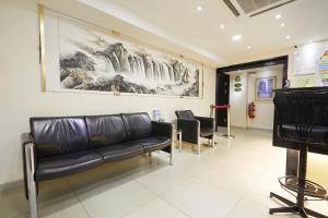 una sala de espera con un sofá de cuero y sillas en SunGold Inn, en Kuala Lumpur