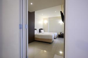 a hotel room with a bed and a mirror at SunGold Inn in Kuala Lumpur