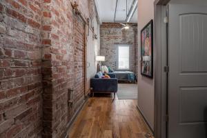 a hallway with a brick wall and a blue chair at The Davis Lofts at Main Street - Unit 3D in Rocky Mount