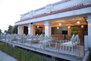 a row of white chairs and tables on a building at Hotel FORT28 in Nagpur