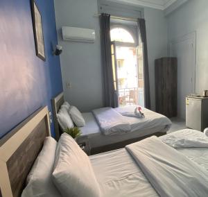 a room with two beds and a window at The Australian Hostel in Cairo