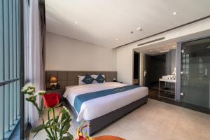a bedroom with a large bed and a bathroom at The Time Hotel in Nha Trang