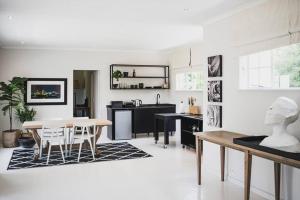 a living room with a table and a kitchen at Stirling Loft in Johannesburg