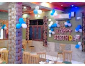 a room with chairs and a table with a happy birthday sign at Flavours Restaurant And Resort "A unit of Sidhbali Restaurant", Dugadda in Lansdowne