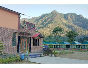 a hotel building with a mountain in the background at Flavours Restaurant And Resort "A unit of Sidhbali Restaurant", Dugadda in Lansdowne