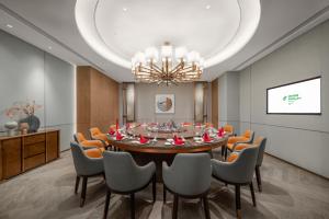 une salle à manger avec une grande table et des chaises dans l'établissement Holiday Inn Fu'an, à Fu'an