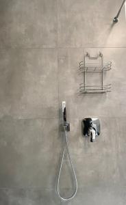 a shower with a hose attached to a wall at PnT home-stilvolles Apartment in Koblenz