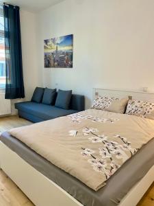 a bedroom with a bed and a blue couch at PnT home-stilvolles Apartment in Koblenz