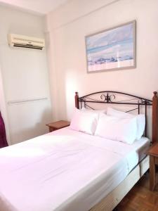 une chambre avec un lit blanc avec des oreillers blancs dans l'établissement teluk kemang senorita homestay, à Port Dickson