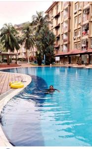 une personne se baignant dans une piscine d'un hôtel dans l'établissement teluk kemang senorita homestay, à Port Dickson